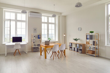 Interior of a new bright modern office with white walls, large windows and workplaces.