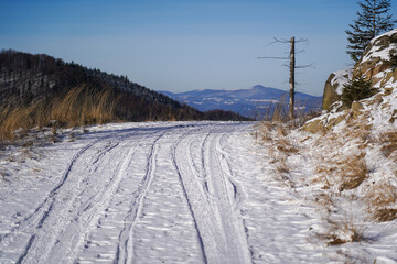 Mountain Road covered with snow in winter sunny day. Beskids Mountain, Poland.