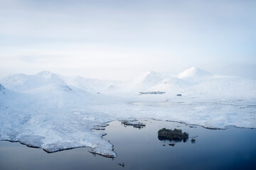 Fototapeta na wymiar Rannoch Moor and Black Mount covered in snow during winter aerial view