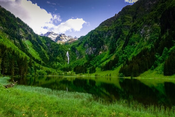 reflection in a lake in the mountains with green landscape