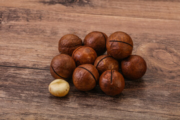Brown macadamia nut heap over background