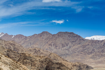 Beautiful landscape of Himalayas barren mountains with white snow, and blue sky,  in Ladakh, Kashmir, view from Thiksey Monastery or Thiksey Gompa.