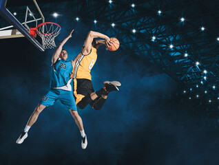 Two basketball players in arena. Blocked shot