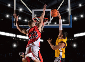 Two basketball players in arena. Blocked shot