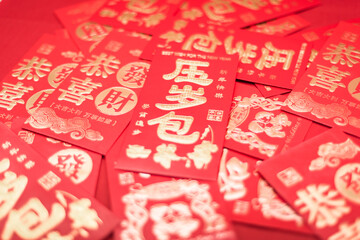 A pile of Chinese New Year red envelopes on red background
