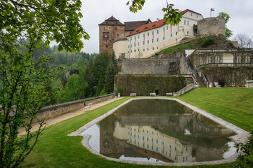 castle in the park. gothic fortress and a baroque castle Bečov nad Teplou (Czech Republic). an old building on a high cliff on a summer day. arched bridge, a well-kept park with a swimming pool 