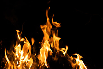 Fire flames on a black background. Abstract fiery texture. Realistic fire flames burn movement frame. Texture for Design. The texture of fire. Fire flames background. Blazing campfire. Sensitive focus
