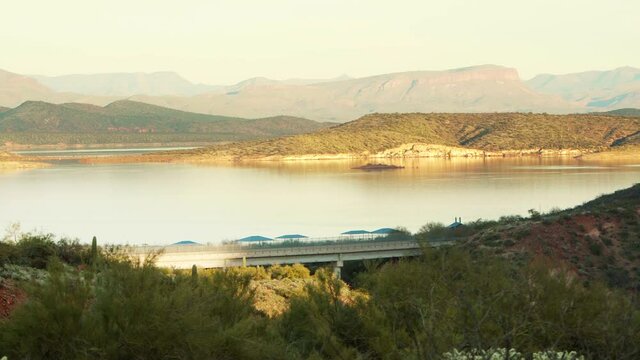 Beautiful sunset at Theodor Roosevelt Lake, Panorama with car passing, crossing bridge. AZ, USA. Panorama right to left.