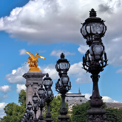 Fototapeta na wymiar Golden sculpture and decorative lamps on the Alexander III bridge (Pont Alexandre III) in Paris, France