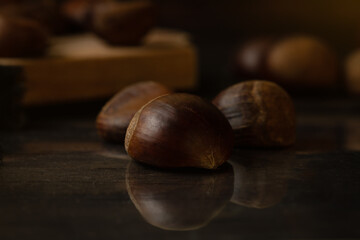 Not roasted fresh chestnuts in a wooden table