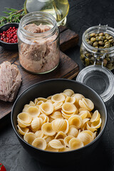 Tuna pasta shells ingredients, on black background