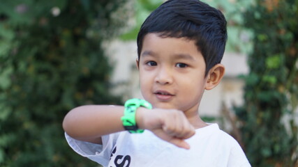 Wearable kids baby smart watch calls mom and location tracking with touch screen and voice service green multicolored electronic gadget with rubber wristband for children. Close up boy with copy space