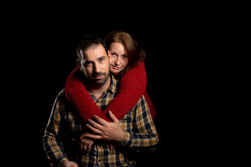 Middle-aged couple with an attitude of love posing on a black background. Copy space. Valentine's Day