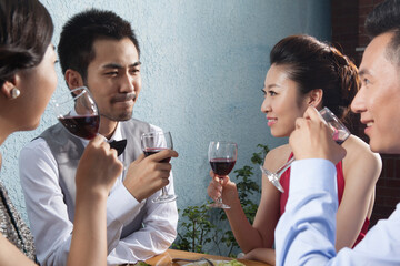 Four people sit together for dinner and chat 