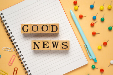 Creative concept good news word on wooden cube. Flat lay view.