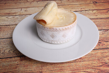 Cheese, Torta del Casar open, on black plate on wooden background top view