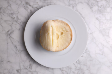 Extremadura cheese (Torta del Casar) in white plate on white marble table