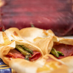 Cecina de León and ham rolled up into an elongated snack. Macro view with background blur