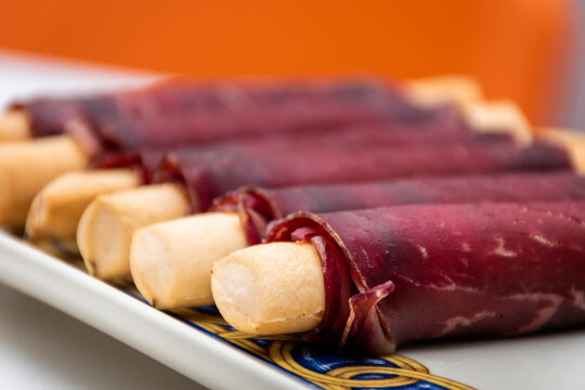 Cecina de León and ham rolled up into an elongated snack. Snack stick. New tapa for bars and restaurants