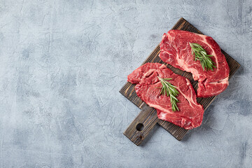 Two Fresh Raw meat Prime Black Angus Beef Steaks, Rib Eye, Denver, on wooden cutting board.