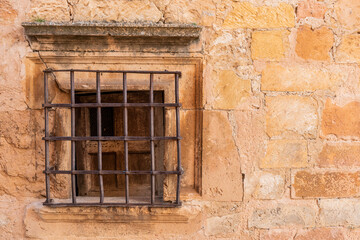Fototapeta na wymiar stone house window with metal grating