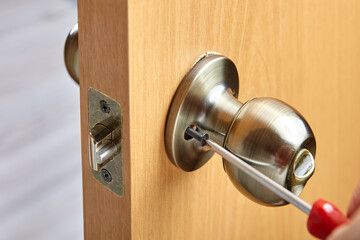 Way of attaching the doorknob using exposed set-screws to secure the handle to a threaded spindle.