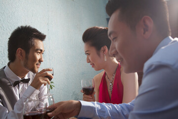 Four people sit together for dinner and chat 