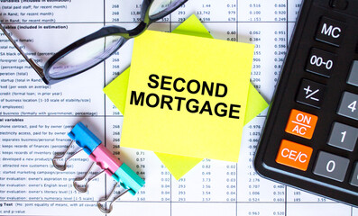 Text Second Mortgage on yellow stickers with calculator, eyeglasses and paper clips