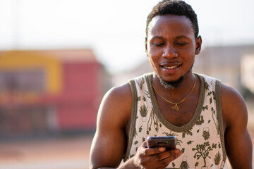 young african man using his phone, checking a notification, reading a message