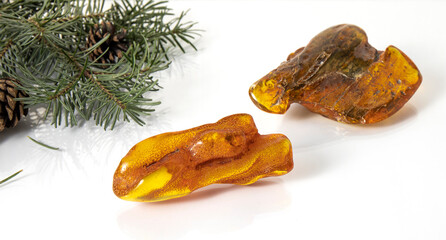 Sparkling big  orange and yellow-green Baltic pieces of amber on a white background. Amber texture, material for jewelers. Ancient amber is protection powers healing luck love and strength. 
