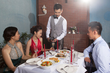 Four people sit together for dinner and chat