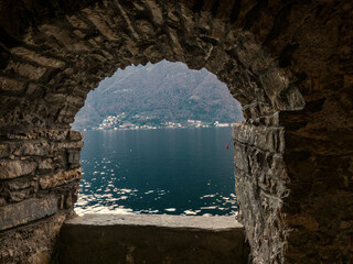Landscape of Como lake seen from a window of an ancient stone building.Lombardy, Italian Lakes, Italy.
