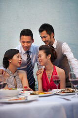 Four people sit together for dinner and chat