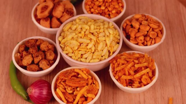 Indian Namkeen indian food in white bowl in white background,Namkeen in a bowl wooden background,Sev murmura,chanadal,shing bhujia,mix chavana,Popular street side indian snacks, India,Namkeen, Farsan,