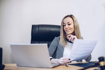 Smiling, satisfied female notary working in her office.