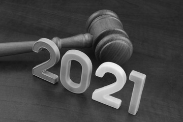 Wooden gavel and numbers 2021 on wooden table. Concept of new  rules.