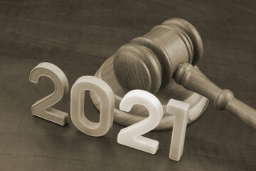 Wooden gavel and numbers 2021 on wooden table. Concept of new  rules.