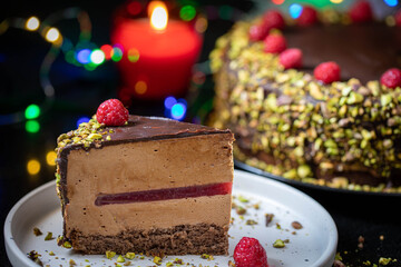 Chocolate mousse cake with raspberry jelly, raspberries and pistachios