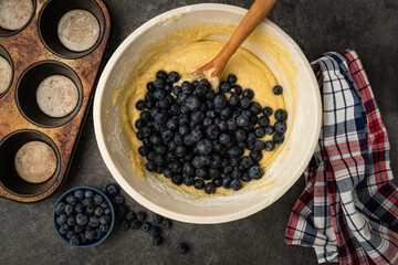 Blueberries being added to the batter to make blueberry muffins