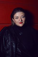 woman in leather jacket on red background