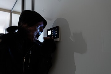 A furious thief tries to disarm the alarm system. Home security alarm. Burglary.