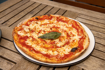 A delicious Margarita pizza on a wooden table