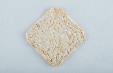 Single airy crispbread on white background