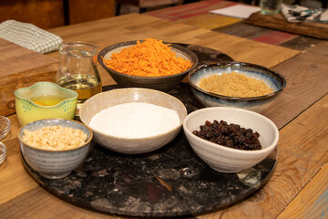 The raw ingredients set out to make a carrot cake on a wooden kitchen work top