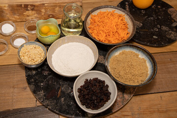 The raw ingredients set out to make a carrot cake on a wooden kitchen work top