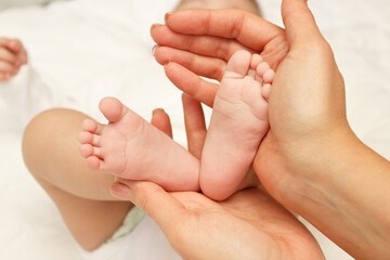 Hands of woman holds baby, blurred background