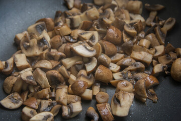 Close up view of sauteed slices of Common Mushrooms (Agaricus bisporus) cooking in the pan