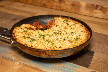 A delicious meal of parsnip shepherd's pie in a pan in a kitchen wooden work top