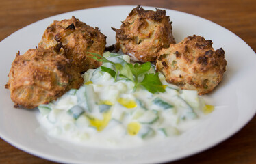 Traditional Greek patties, made of leek and cheese, served with Tzatziki sauce in a plate

