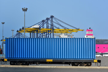 Cargo train platform with freight train Containers on the train on crane loading in port background.